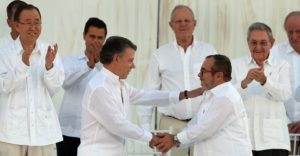 Colombia’s President Juan Manuel Santos, left, and the top commander of the Revolutionary Armed Forces of Colombia (FARC) Rodrigo Londono, known by the alias Timochenko shake hands after sign a peace agreement between Colombia’s government and the FARC in Cartagena, Colombia, Monday, Sept. 26, 2016. (AP Photo/Fernando Vergara)